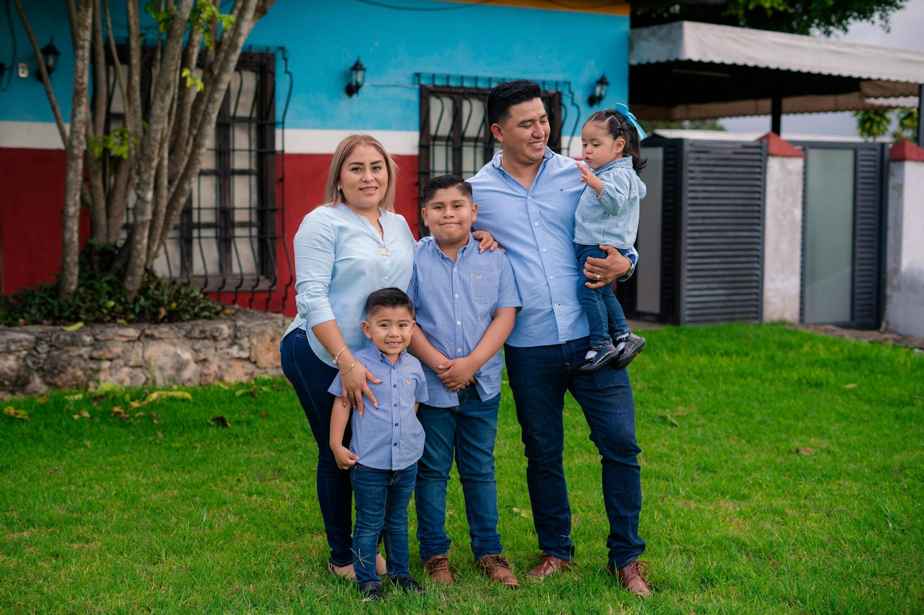 happy family posing outside a colorful house