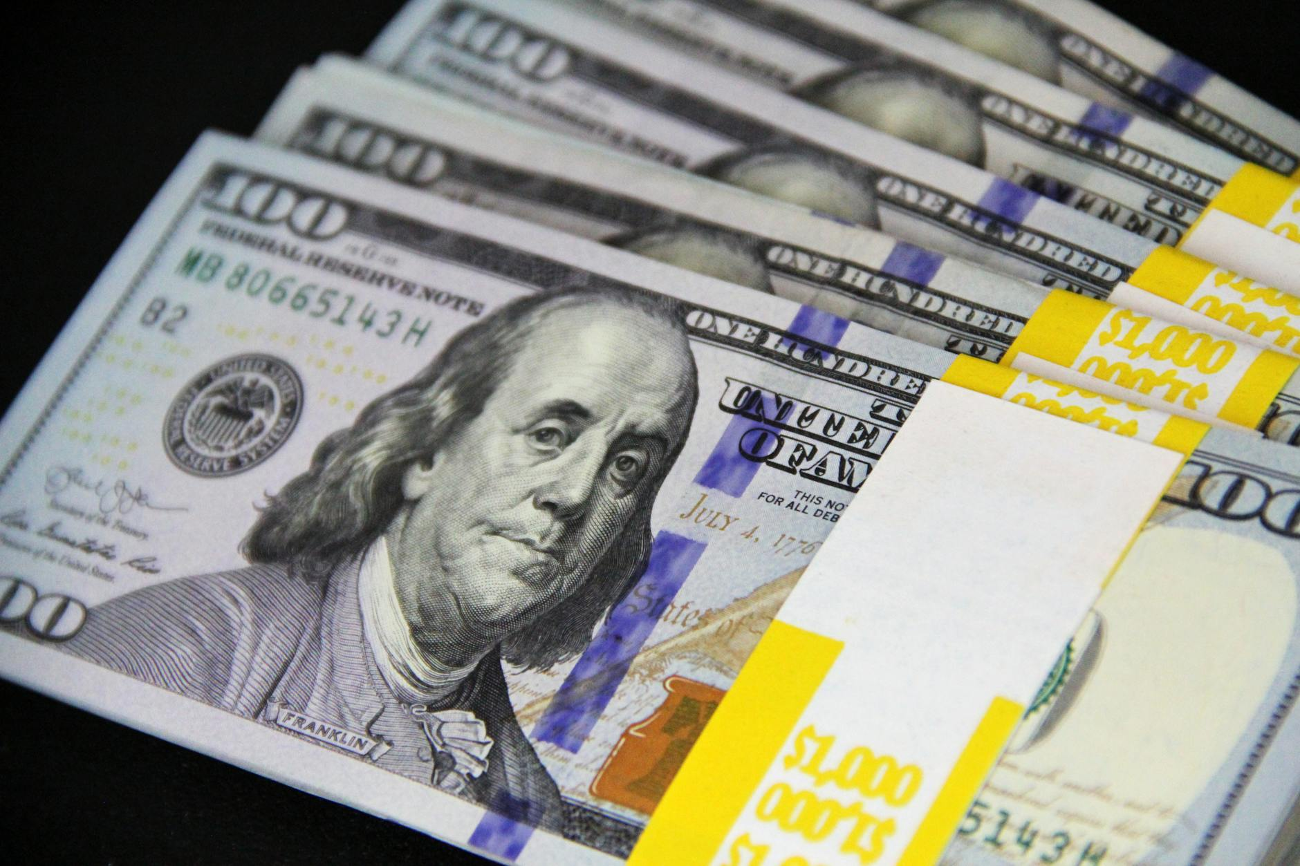 bundles of banknotes on black surface